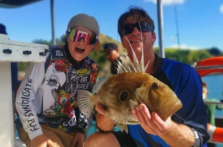 Guests with a John Dory catch on a fishing charter